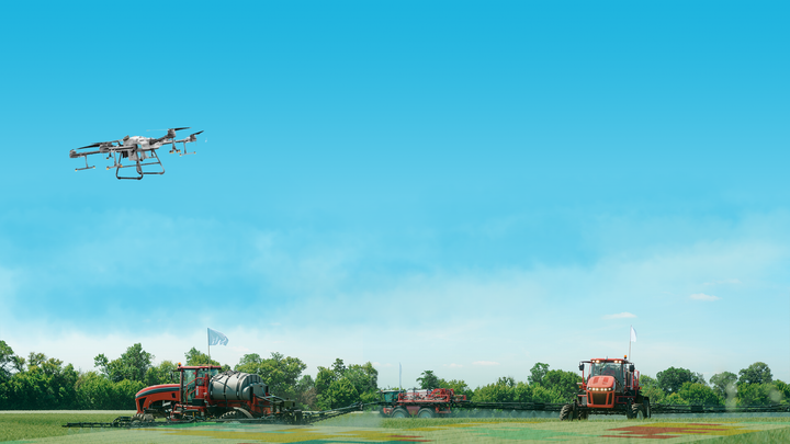Spray drone and tractors treating a field using Agremo spraying maps